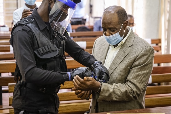 Paul Rusesabagina is handcuffed by a police officer after his pre-trial court session at the Kicukiro Primary court in Kigali, Rwanda, on September 14, 2020.
