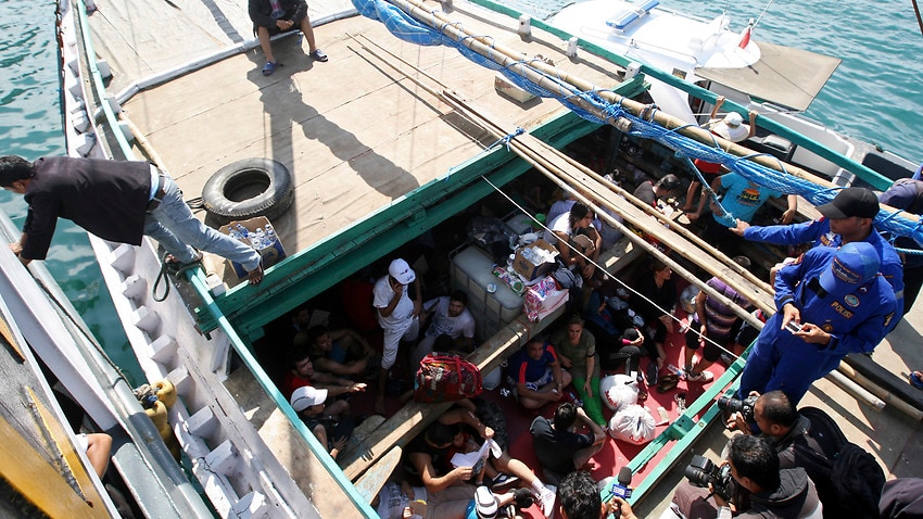 Iranian asylum seekers who were caught in Indonesian waters while sailing to Australia sit on a boat at Benoa port in Bali, Indonesia.
