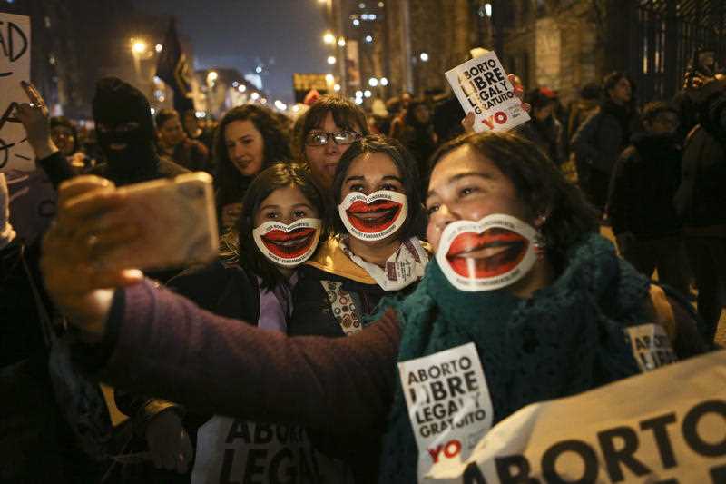 Girls pose for a photo during a march in favor of a bill backed by Chile's President Michelle Bachelet, to legalize abortions in three situations.