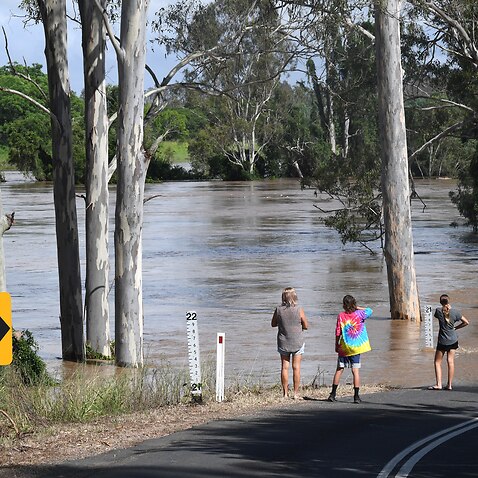 People are seen watching the flood waters from the Mary River rise in the town of Tiaro on 9 January. 