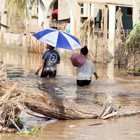 People affected by storms Eta and Iota navigate a flooded street in La Guadalupe, Honduras, on 30 November.