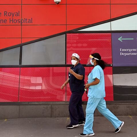 Medical staff walk past the emergency entrance at the Royal Melbourne Hospital in Melbourne on 9 October, 2021. 