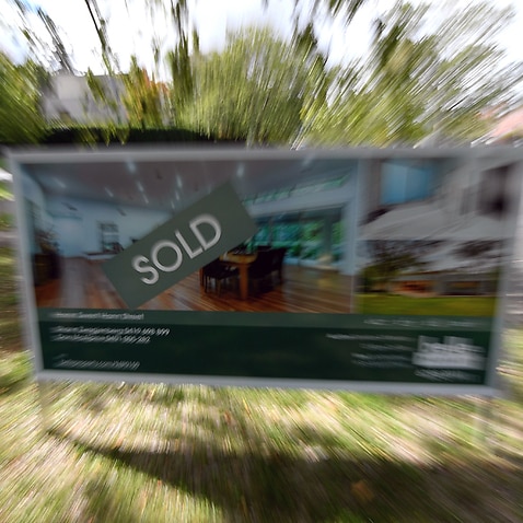 A real estate advertising board with a Sold sign