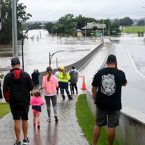 Onlookers watch on as the Windsor Bridge is impacted by floodwater from the Hawkesbury river at Windsor, north west of Sydney, Thursday, 3 March, 2022.