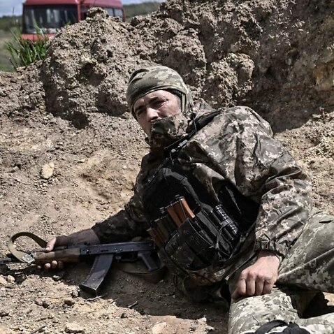 A Ukranian serviceman takes cover during shelling outside the city of Lysychansk in the eastern Ukranian region of Donbas, on 23 May 2022