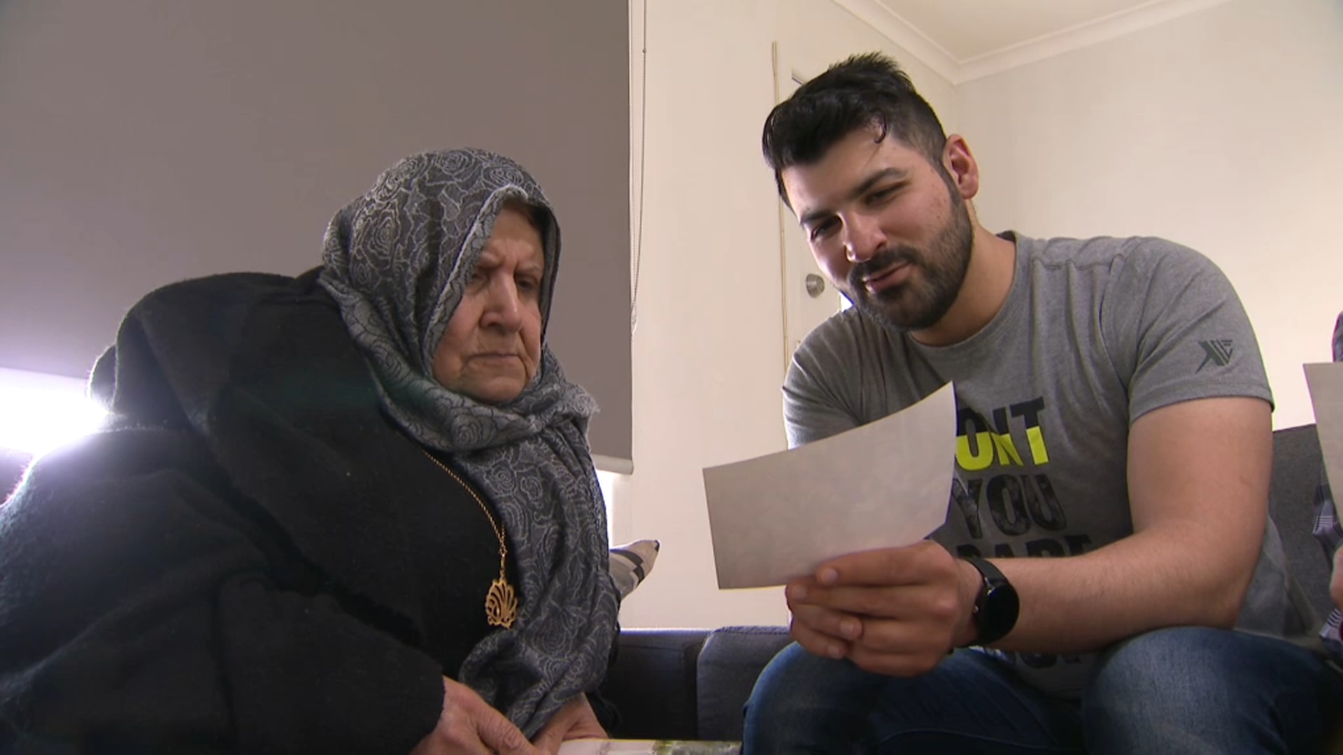 Ammar al Taie looks through photos with his mother of their previous lives in Iraq. 
