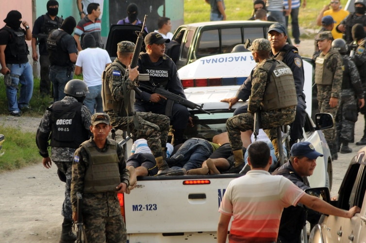 Police arrest gang members after a firefight in San Pedro Sula, Honduras. Police arrest gang members after a firefight in San Pedro Sula, Honduras.