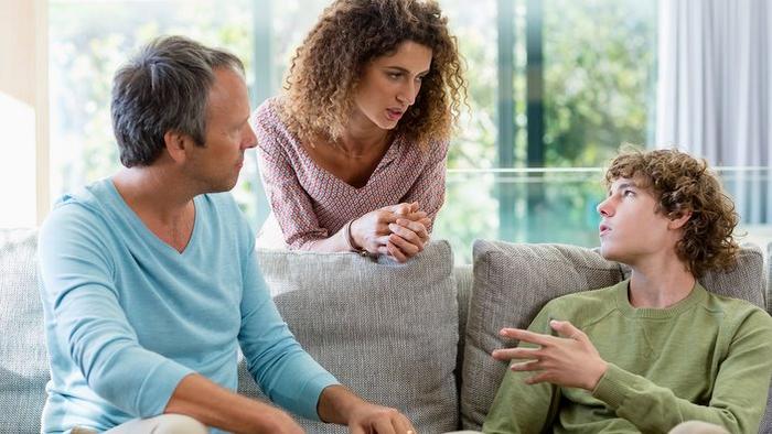 Boy And Parents Talking In Living Room