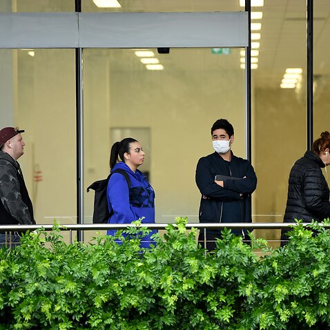 People are seen queuing outside a Centrelink office in Bondi Junction, Sydney, Tuesday, March 24, 2020