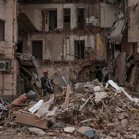 Firefighters clear the debris and search for bodies under the rubble of a building hit weeks ago by a Russian attack after receiving reports of a smell emerging from the area, in Kharkiv, Ukraine, Monday, April 11, 2022. (AP Photo/Felipe Dana)