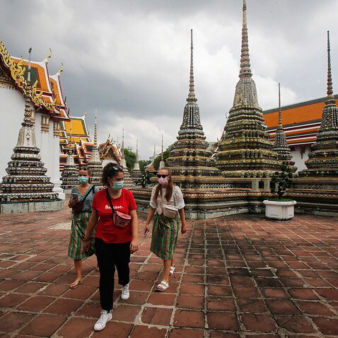 Tourists visit a temple in Bangkok.