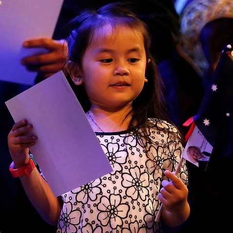 Four-year-old Bella Adlan receives her citizenship certificate and flag in Newcastle 