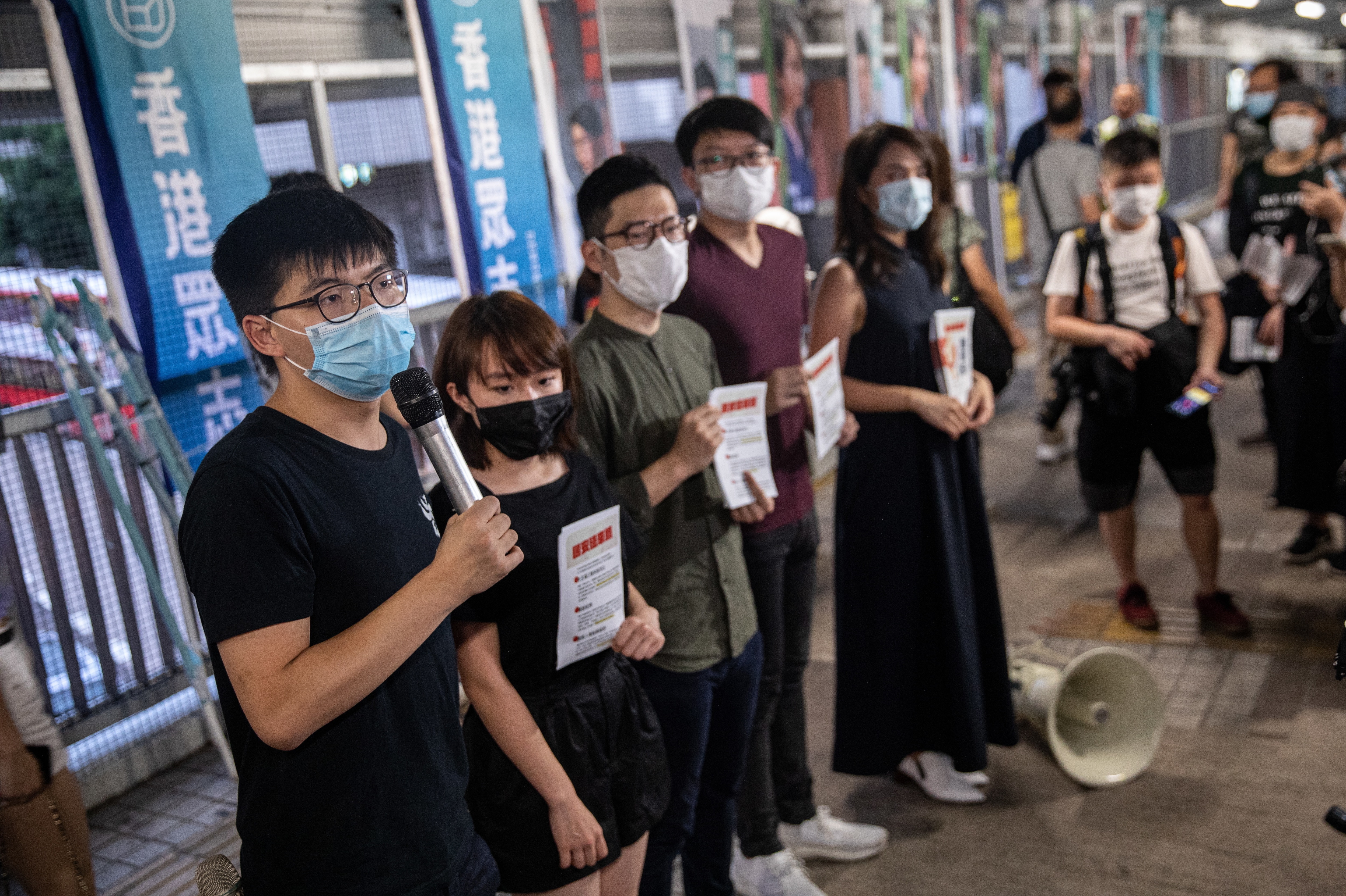 Pro-democracy activists and Demosisto members all wearing face masks, distribute flyers against China's controversial national security law. Pro-democracy activists and Demosisto members all wearing face masks, distribute flyers against China's controversial national security law.