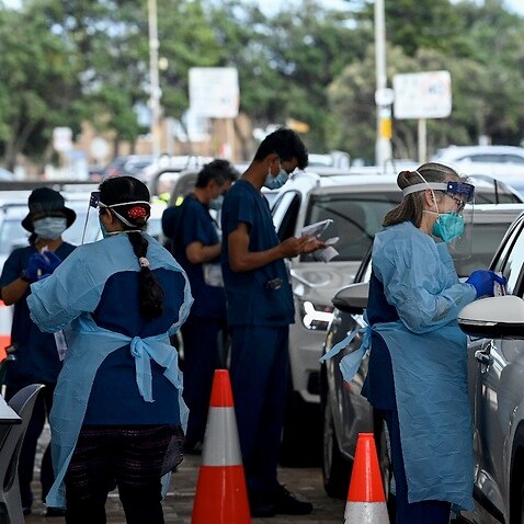 Healthcare workers administer COVID-19 PCR tests at the St Vincent’s Drive-through Clinic at Bondi Beach in Sydney on 1 January 2022.