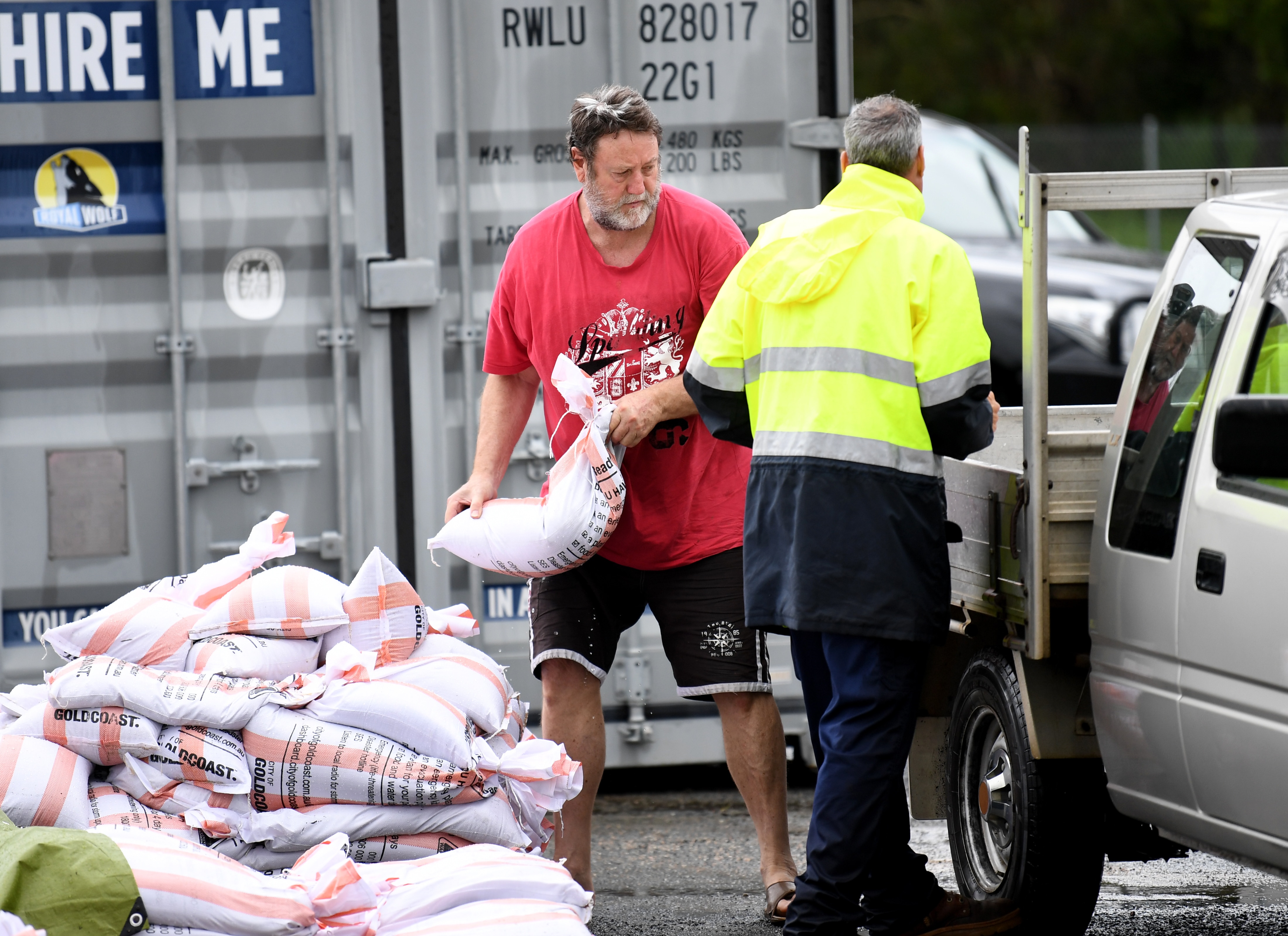 A man loads up sandbags to his car at Pimpama on the Gold Coast, on Sunday, 13 December.