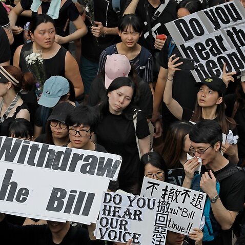 Protesters raise placards as they march on the streets against an extradition bill in Hong Kong.