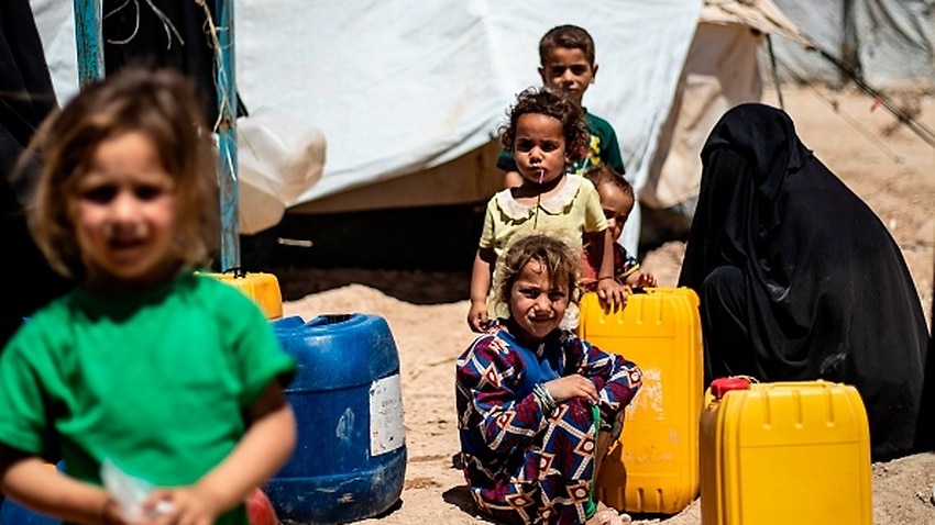 Displaced Syrians queue for water inside al-Hol camp for displaced people in northeastern Syria.