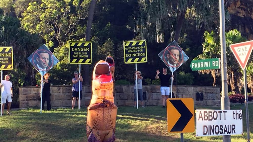 Dinosaur costumes are part of an unconventional campaign to oust Tony Abbott. 