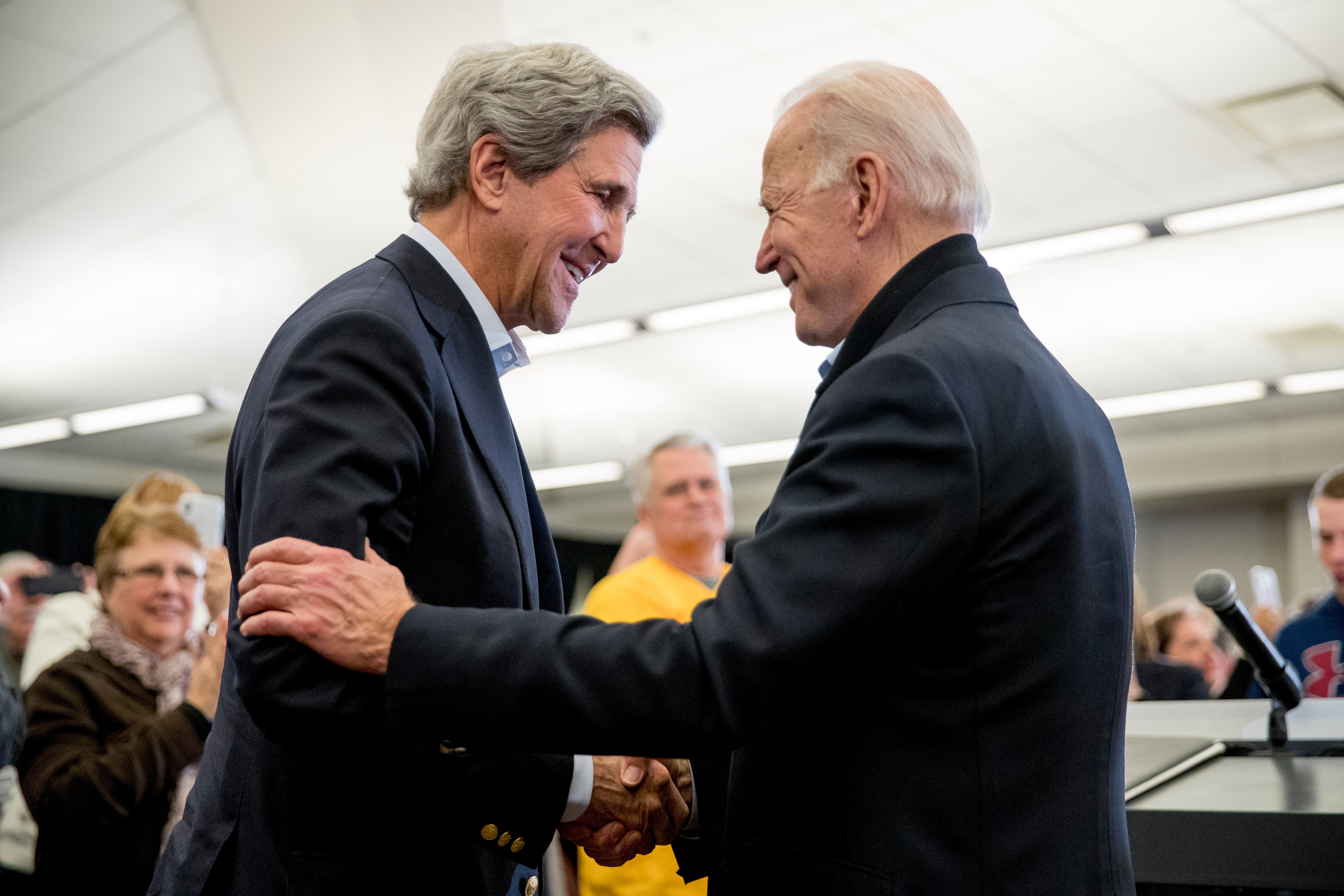 Joe Biden smiles as former Secretary of State John Kerry, left, speak at a campaign stop in North Liberty, Iowa in February, 2020. 