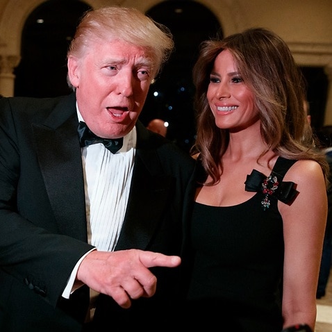 Melania Trump, right, looks on as her husband President-elect Donald Trump talks to reporters during a New Year's Eve party at Mar-a-Lago, Saturday, Dec. 31, 2016, 