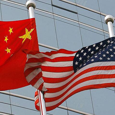 A US and a Chinese flag wave outside a commercial building in Beijing