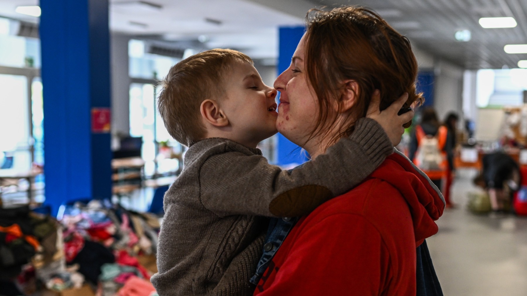 A woman who fled the war in Ukraine comforts a child inside a sports hall that has been converted for a temporary shelter on Nowa Huta district, March 15, 2022.