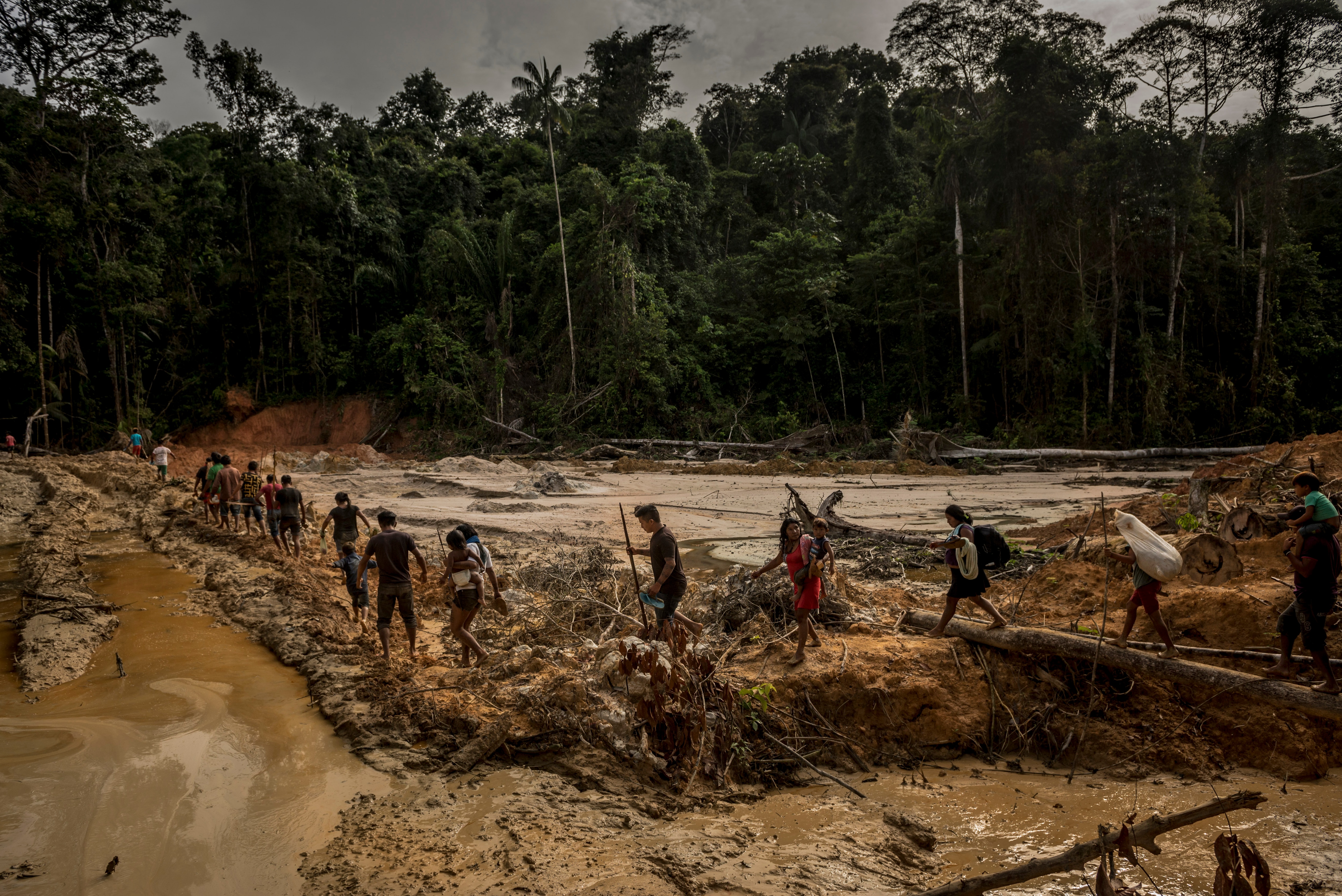Members of the indigenous Munduruku tribe cross protected land in Brazil that was destroyed by illegal gold mining. Members of the indigenous Munduruku tribe cross protected land in Brazil that was destroyed by illegal gold mining, deep in the Amazon rainforest.