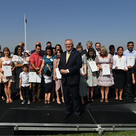 Prime Minister Scott Morrison poses for photos with new citizens during an Australia Day Citizenship Ceremony and Flag Raising event in Canberra.