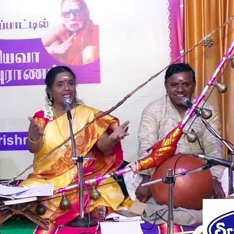 Bharathi Thirumagan on stage with her son to her right and her husband to the left