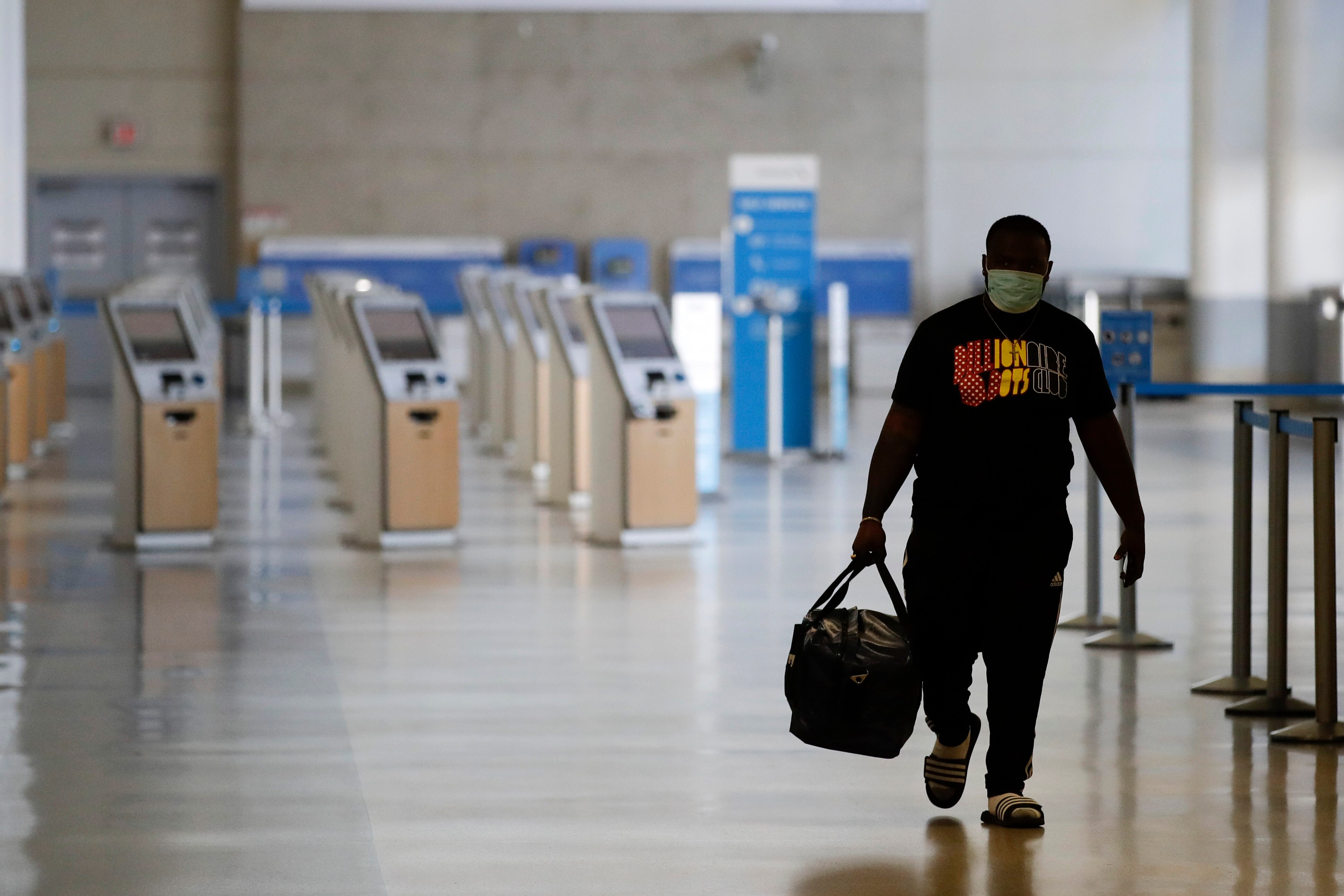 A traveller walks in a mostly empty American Airlines terminal at the Los Angeles International Airport in May. 