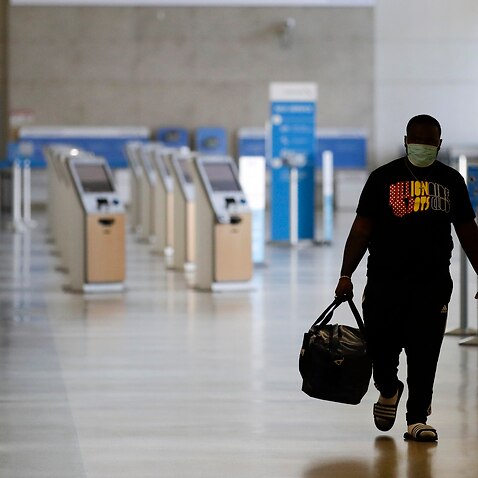 A traveller walks in a mostly empty American Airlines terminal at the Los Angeles International Airport in May. 