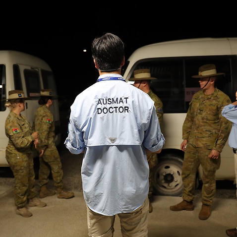 An AUSMAT doctor briefs military personnel before the arrival of an Australian evacuee flight on Christmas Island.