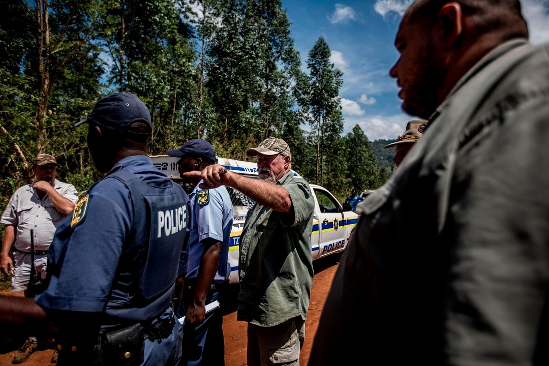 A farmer speaks to South African police after an incident in which a farm worker was held at gunpoint.