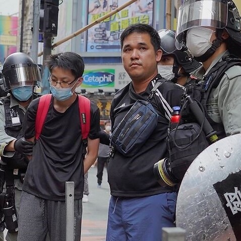 Riot police arrest protesters during a rally against a proposed security law.