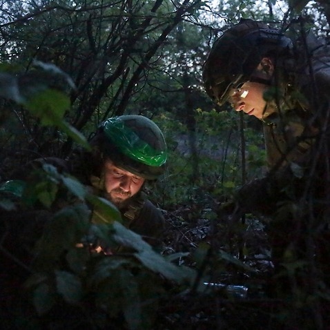 Ukrainian servicemen watch a map on their position near Kharkiv, Ukraine
