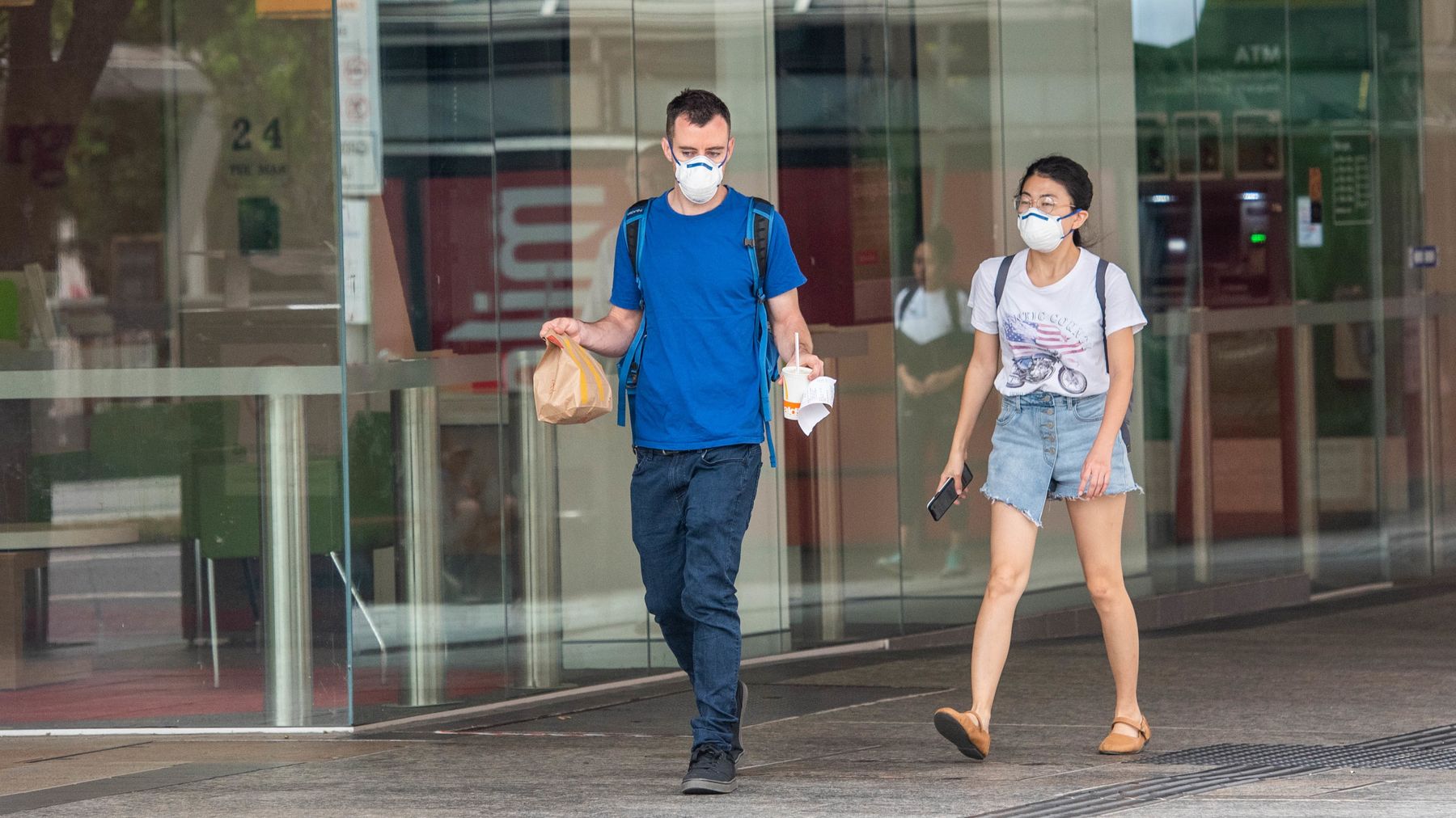 People wearing face masks after picking up food in Brisbane. 