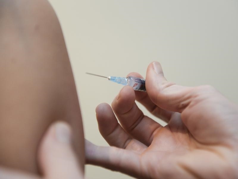 A hand holding a syringe preparing to inject/ Kids under five in Tasmania can receive a free flu shot by GPs before winter. (AAP)