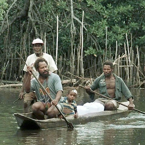 Villagers from Sissano in northern Papua, New Guinea, use a dugout canoe to bring supplies.