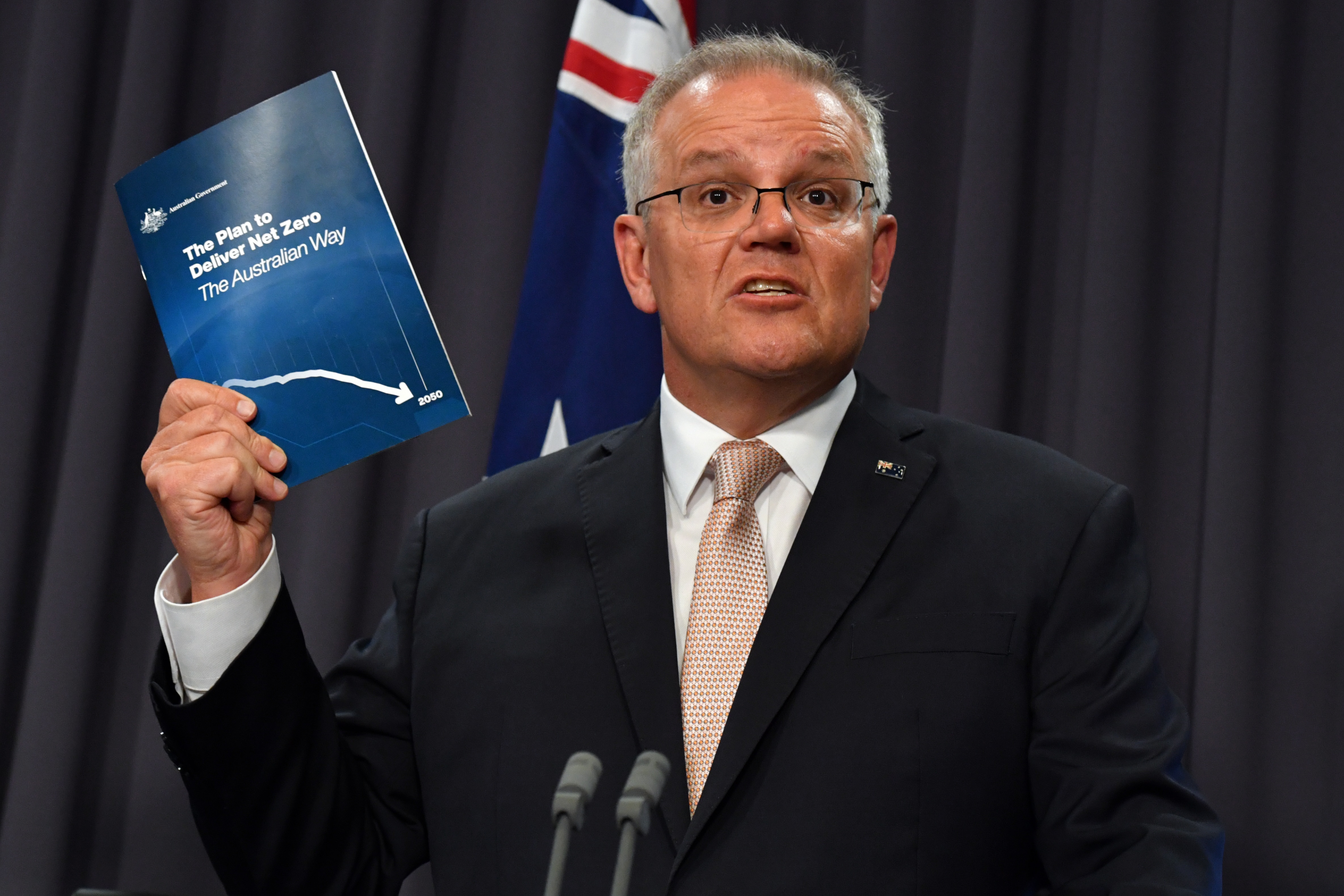 Mr Morrison holds a document outlining his net zero emissions plan.