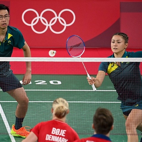 Australia's Gronya Somerville hits a shot next to Simon Wing Hang Leung in their mixed doubles badminton match during the Tokyo 2020 Olympic Games