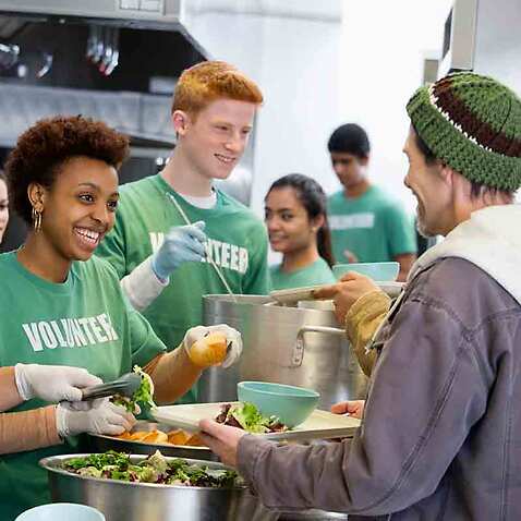 Volunteers serving food for homeless people