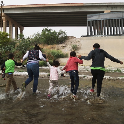 Migrants cross the border between the US and Mexico at the Rio Grande river, as they enter El Paso, Texas.