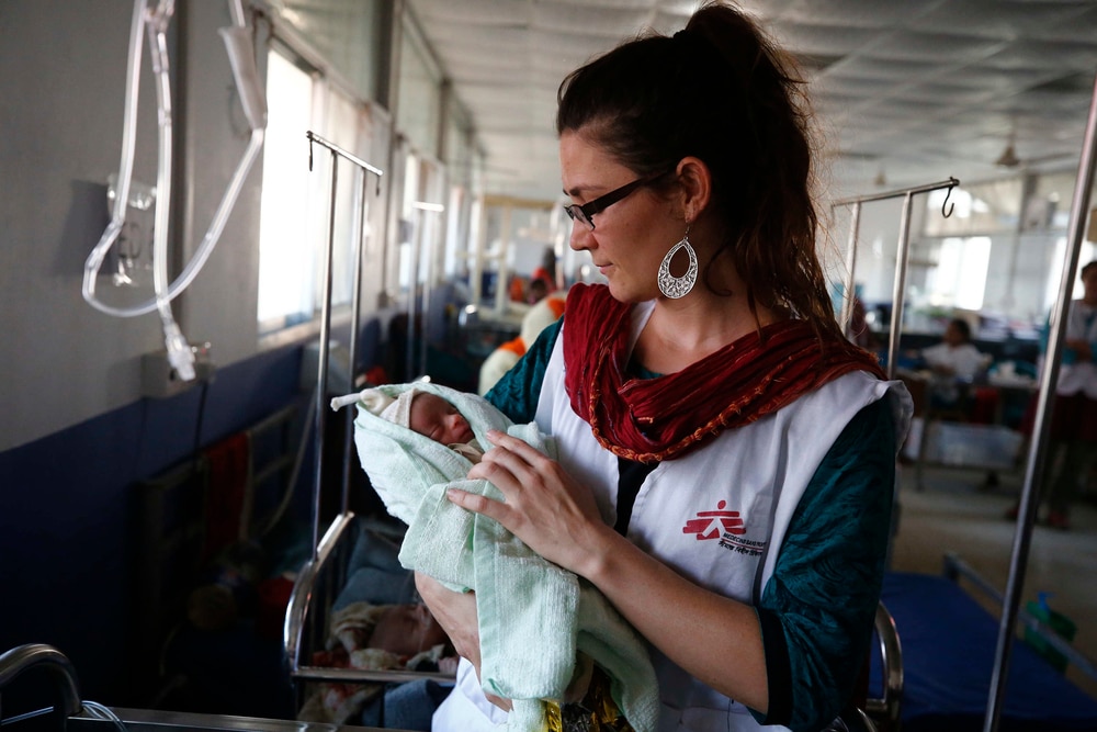 An MSF nurse holds a newborn inside the Kutupalong MSF Hospital. Sophie, an MSF nurse, with a little baby in Kutupalong MSF Hospital.