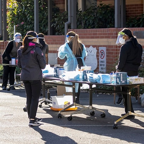 Staff members of the Royal Freemasons Coppin Centre receive COVID tests in the carpark, in Melbourne, Monday, May 31, 2021.  (AAP Image/Daniel Pockett) NO ARCHIVING