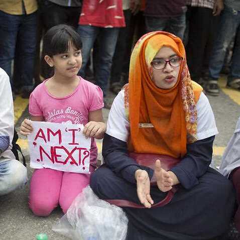 A Bangladeshi child holds a placard, as she participates with protesting students in Dhaka, Bangladesh.