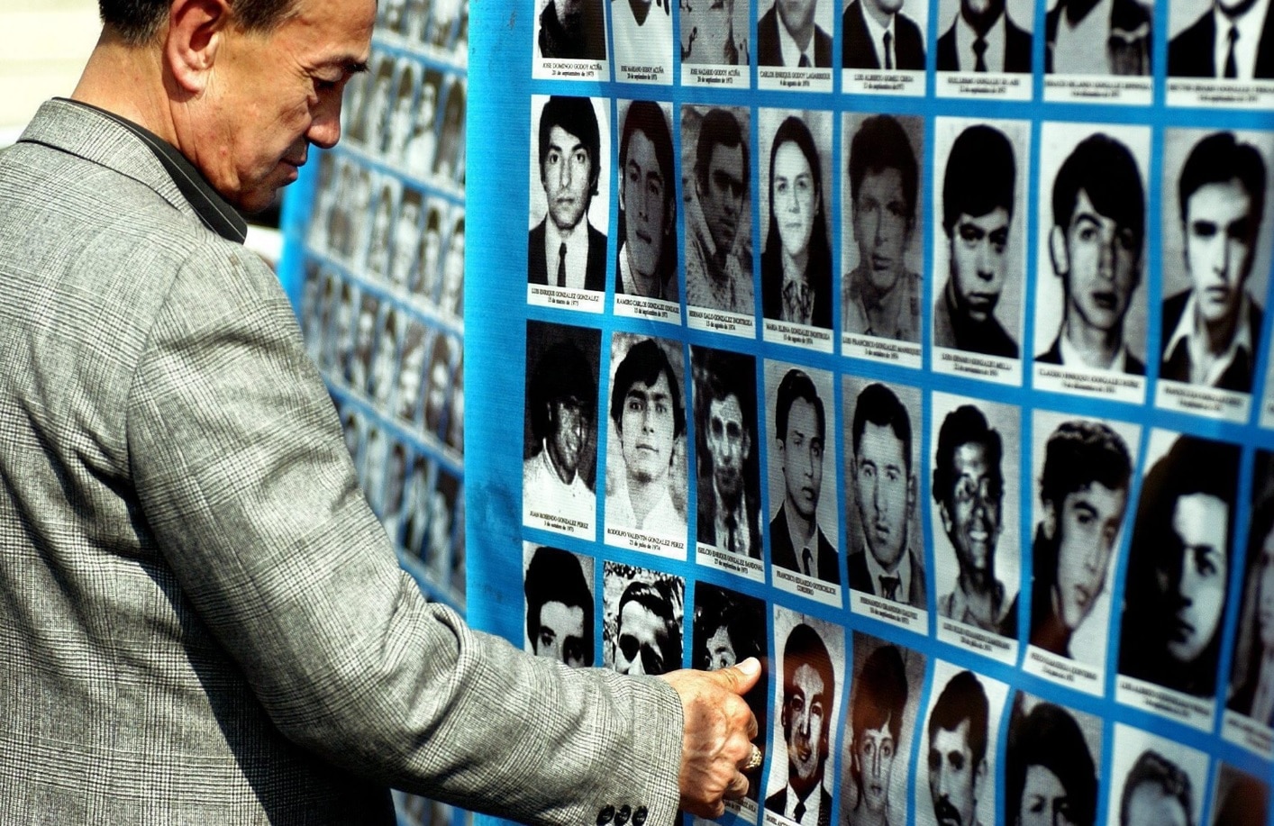 Familiares de desaparecidos y detenidos miran imágenes de sus seres queridos en la plaza principal de Santiago de Chile.