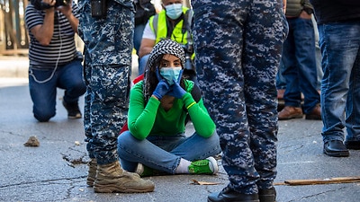 An anti-government protester blocks a road during May Day protest near the Lebanese Central Bank in Beirut.