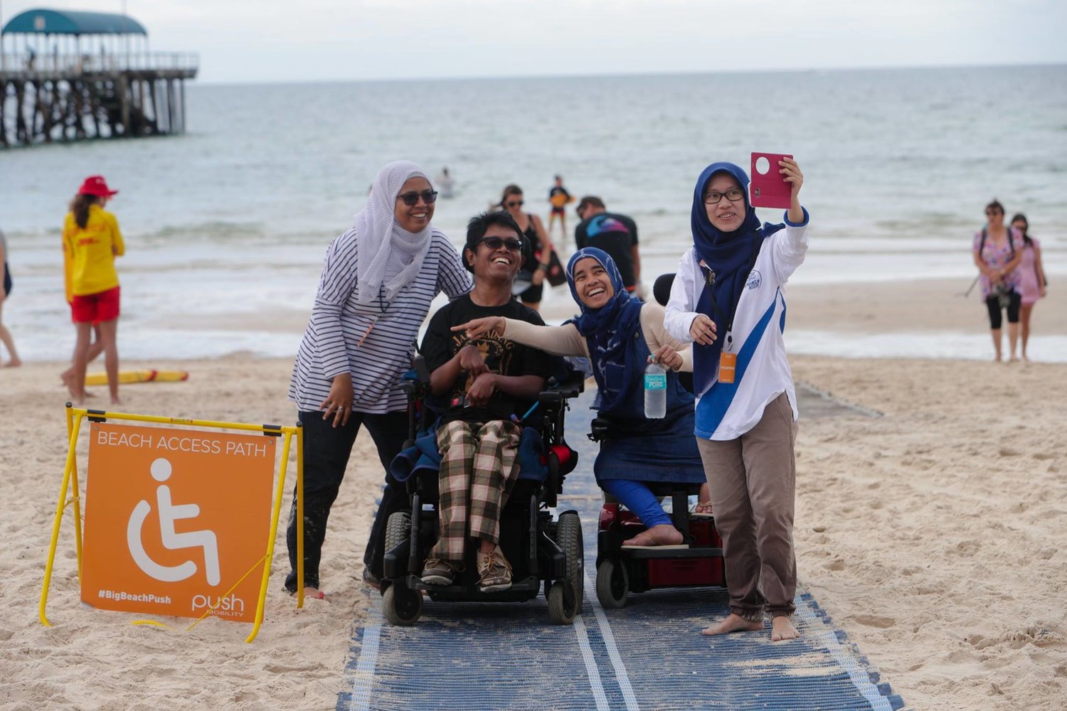 People making use of a beach mat, which allows wheelchair users to move freely across the sand.