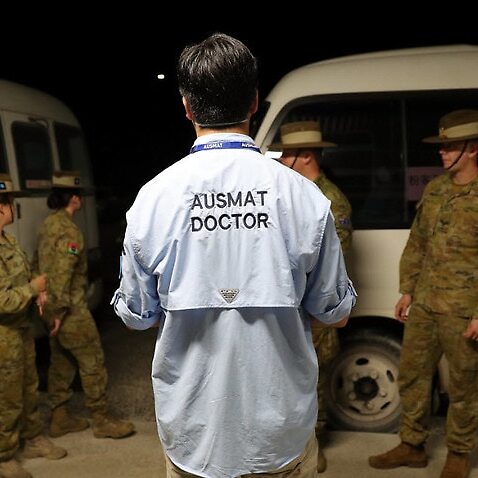 An AUSMAT doctor briefs military personnel before the arrival of an Australian evacuee flight on Christmas Island