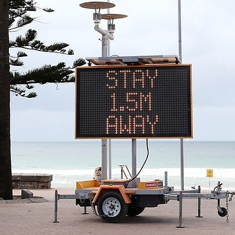 A sign reminding residents and tourists of new social distancing rules at Manly Beach in Sydney